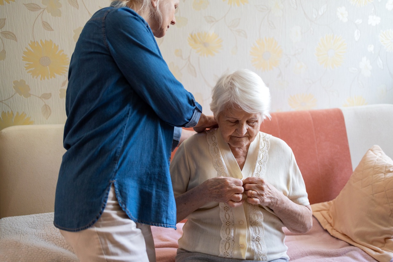 Caregiver helping senior with dressing